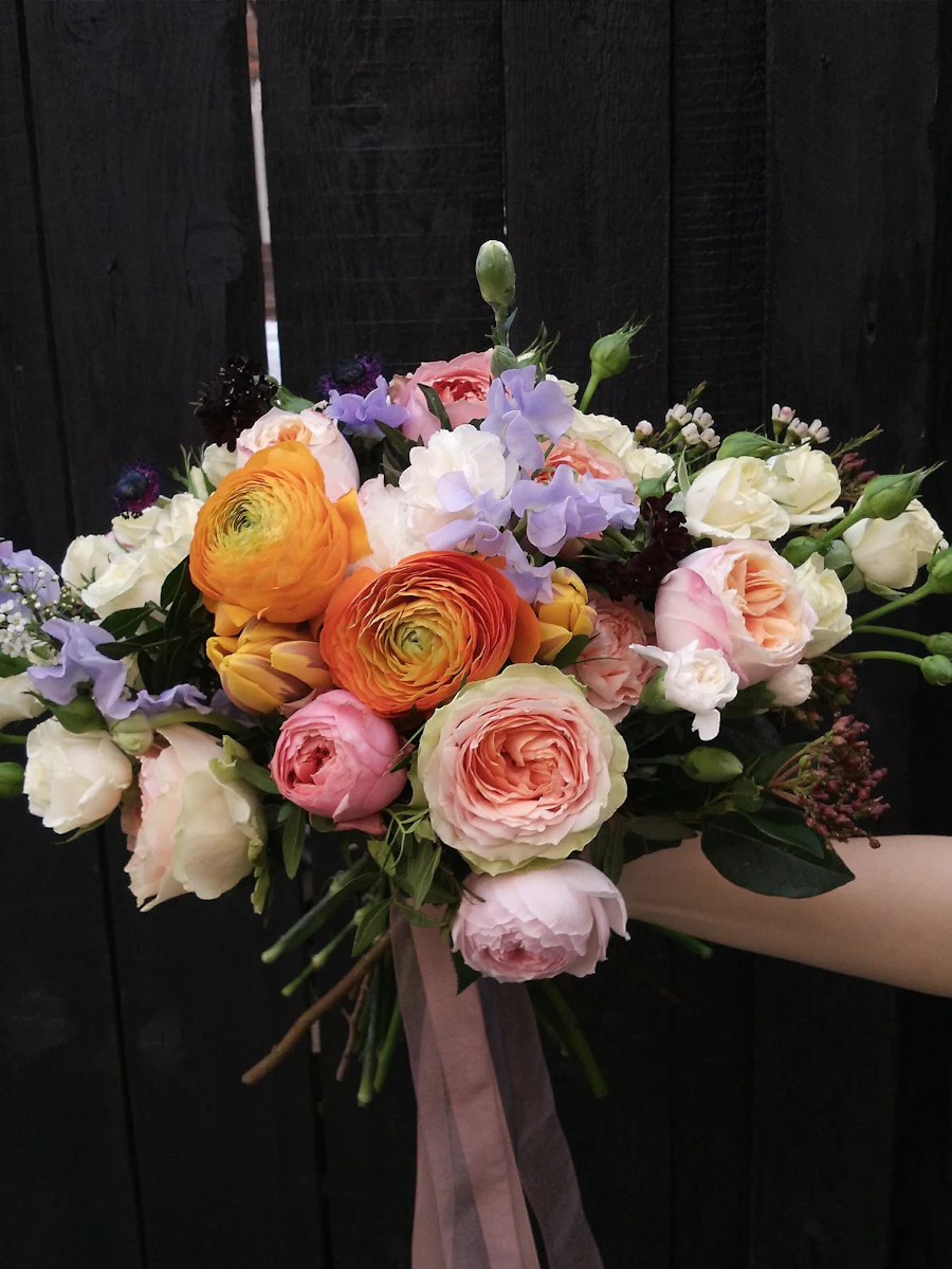 A hand holding a colorful bouquet