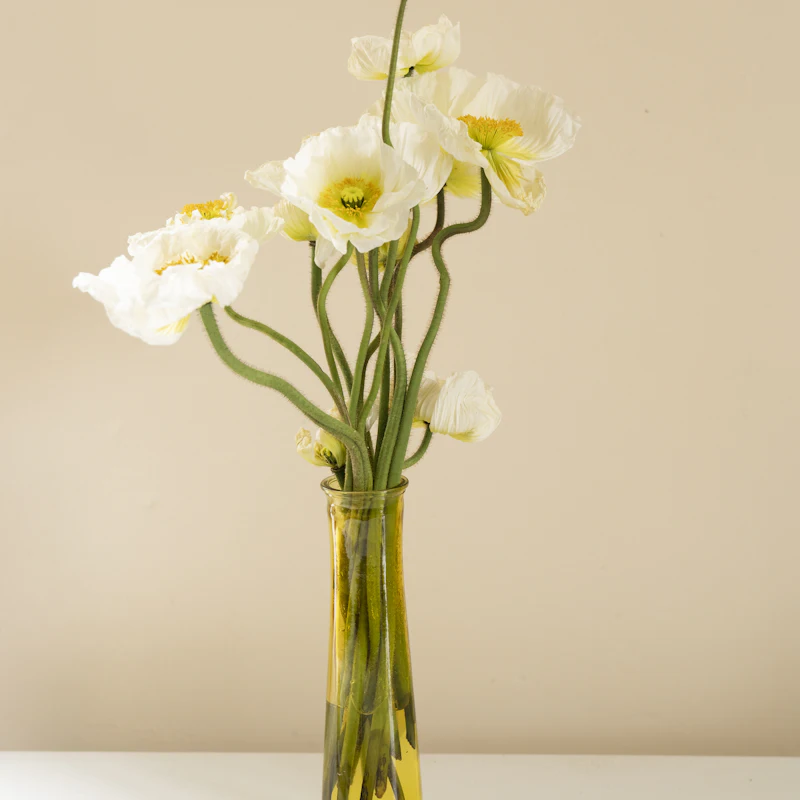 White poppies in an amber glass vase
